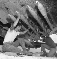 Rockets being loaded under wing of F4U, Okinawa