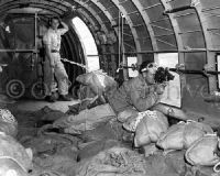 Signal Corps Photographer shooting film while dropping supplies