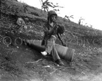 Marine resting on 16-inch naval shell, Saipan