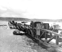 Trucks and tanks move along road, Omaha Beach