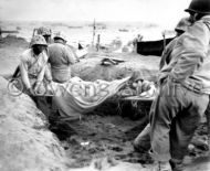 Soldiers carry wounded Japanese POW for evacuation