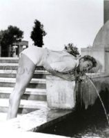 Esther Williams bending over water fountain